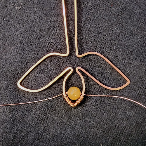 Jennifer Brooks's Rosy Maple Moth Pendant - , Contemporary Wire Jewelry, Lashing, Wire Lashing, Wire Wrapping, Wrapping, Wire Wrapping Jewelry, Thread both sides of the wrapping wire through the second bead.